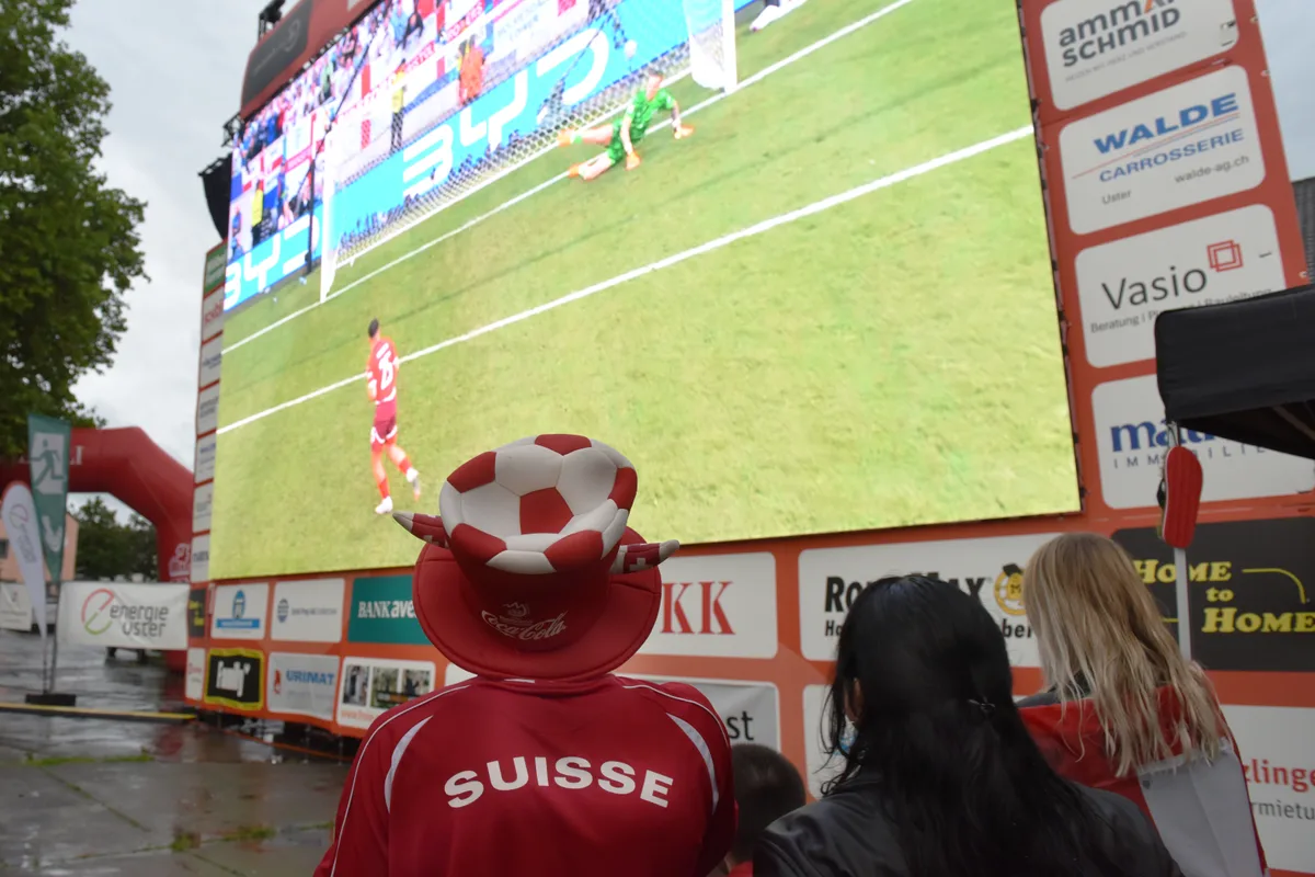 Ein grosser Bildschirm auf dem Fussball läuft.
